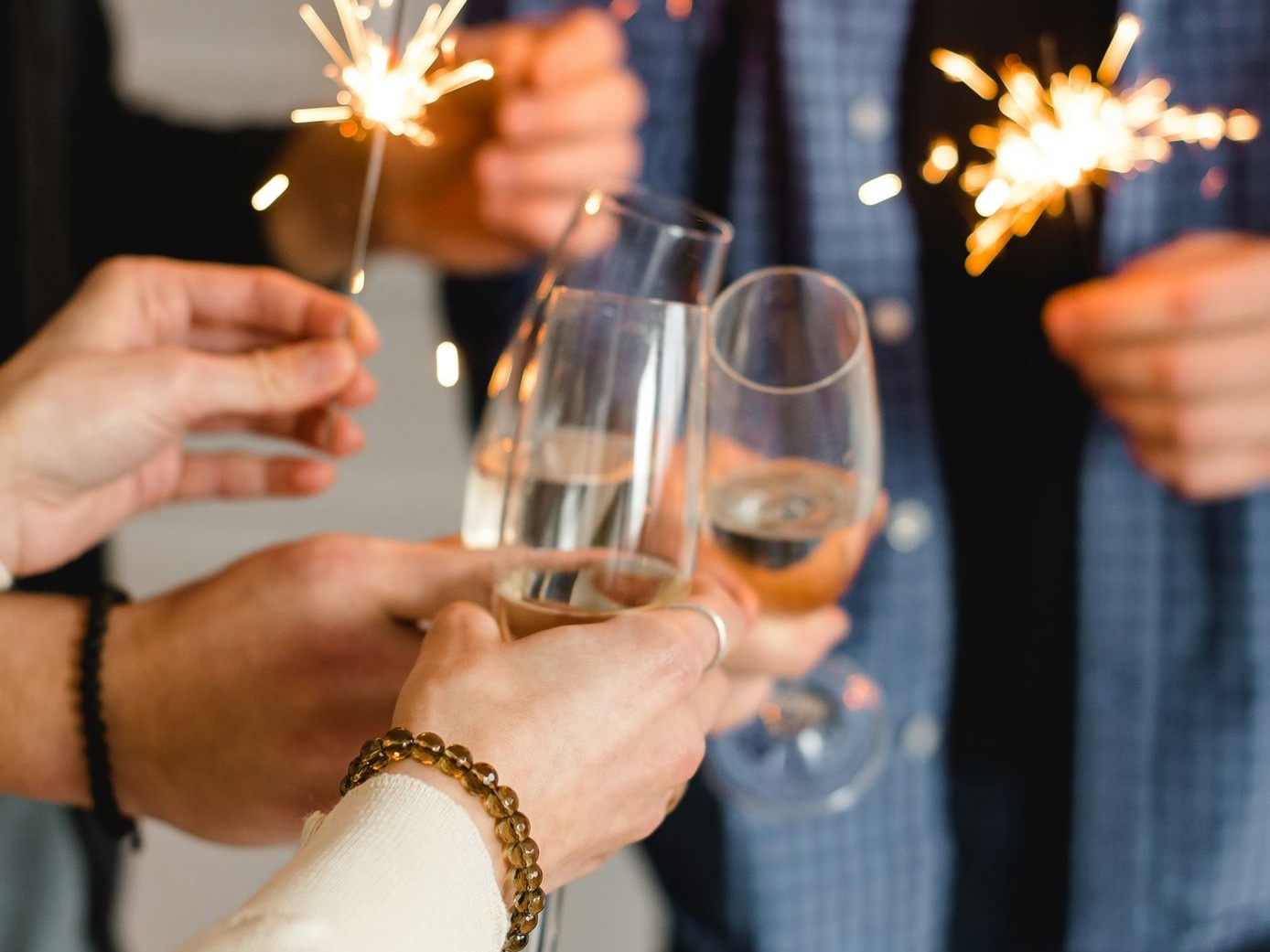 woman in white long sleeve shirt holding clear wine glass